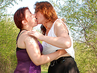two old and young lesbians go at outside in the woods